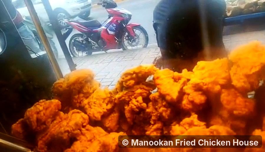 A pile of golden, crispy fried chicken in the display case at Manookan Fried Chicken House